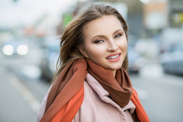 快乐的女人。特写照片的美丽微笑的牙齿阳光女商人看着你的相机红绿色的背景。多元文化，混血，亚洲俄罗斯模式。幸福的概念图片下载