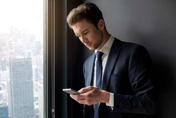 一位严肃的时尚男士正在用智能手机阅读坏消息图片下载