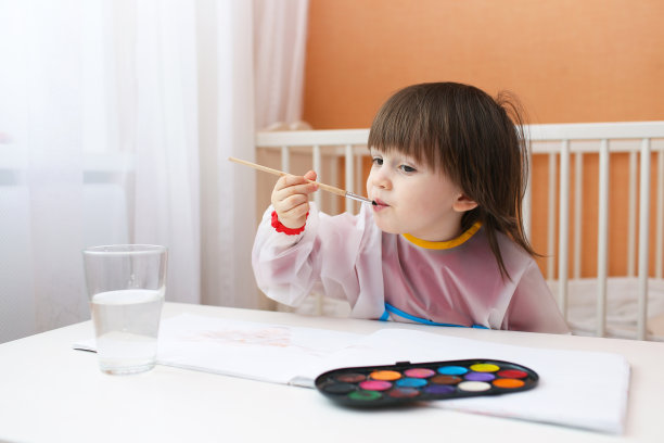 小男孩拿着毛笔和水彩画图片下载