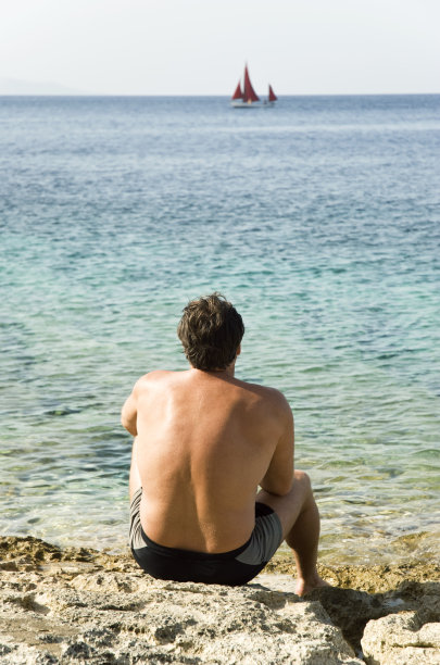 人们坐在海边的岩石上图片下载