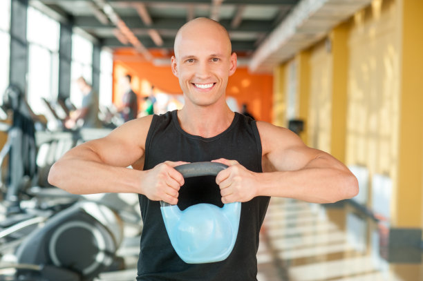 举壶铃的人在健身房锻炼图片下载