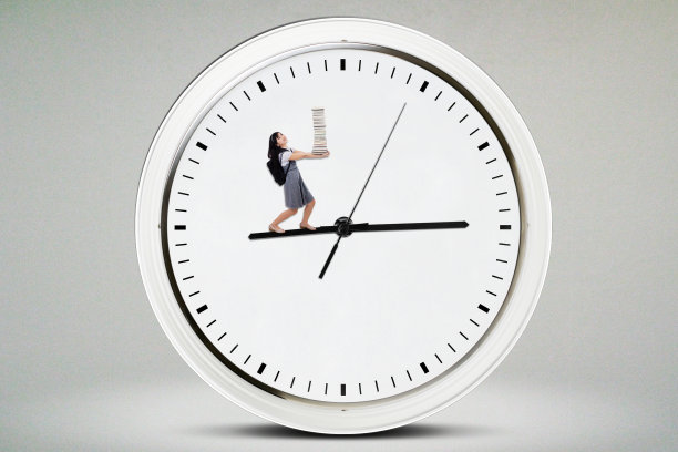 女学生拿着书在钟上图片下载