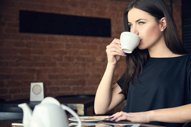 年轻女孩在咖啡馆喝茶图片下载