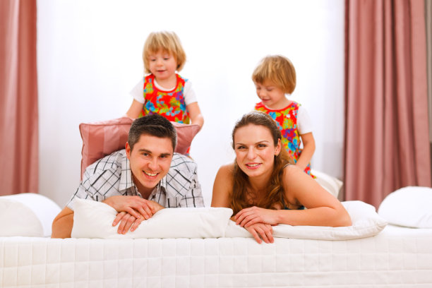 两个微笑的双胞胎女儿坐在父母的背上图片下载