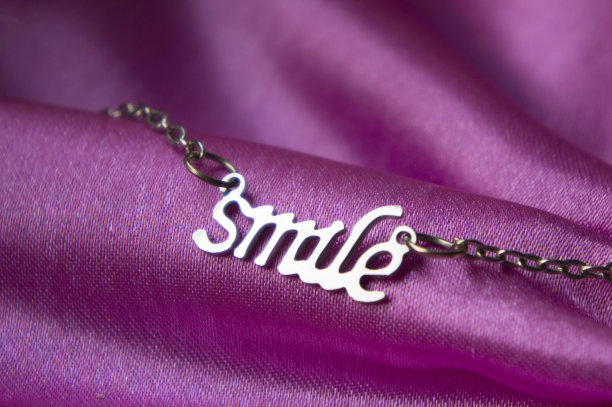 微笑字项链珠宝在粉红色的背景。图片下载