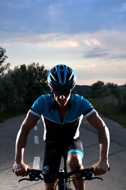 骑山地车的人沿着一条孤独的道路图片下载