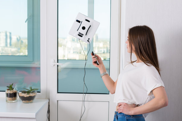 女人用机器人清洁窗户图片下载