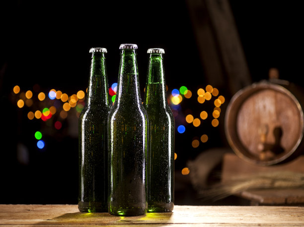 酒吧灯光背景上有啤酒瓶和木桶图片下载