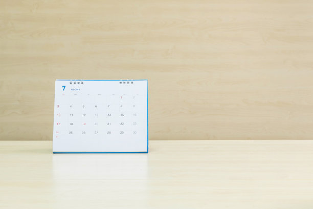 模糊的木桌和墙上挂着七月的特写日历图片下载