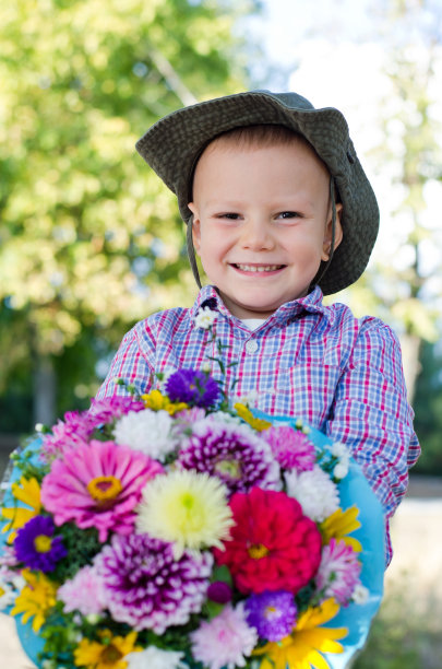 笑容满面的小男孩拿着花给妈妈图片下载