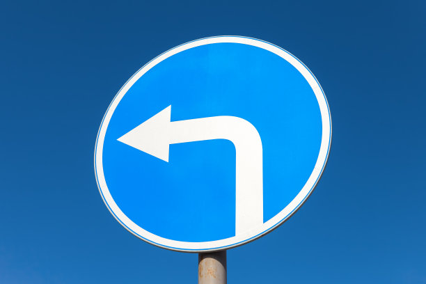 路牌在蓝天下向左转图片下载