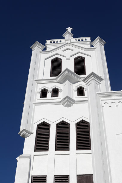 白色灰泥教堂正面，交叉，强烈的蓝色天空。副本的空间。图片下载