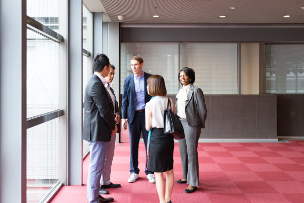 国际商务人士在办公楼的大厅里交谈图片下载