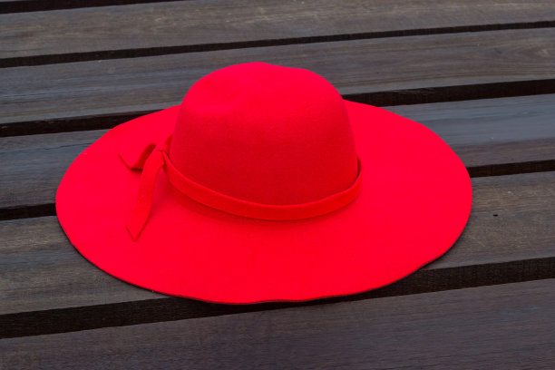 红帽子放在木地板上图片下载