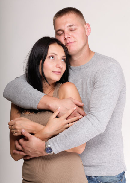 美丽沉思的男人女人站在灰色的墙壁附近图片下载