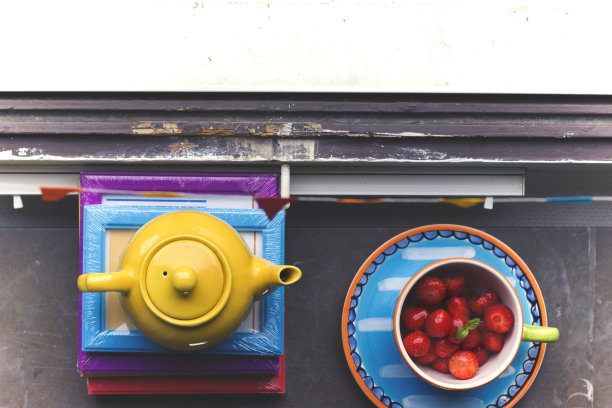 黄色的茶壶和杯子，上面放着草莓图片下载