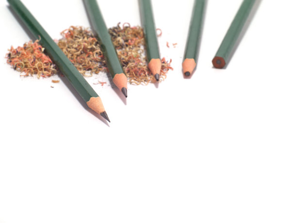 五支削尖的和未削尖的绿铅笔，上面有铅笔屑图片下载