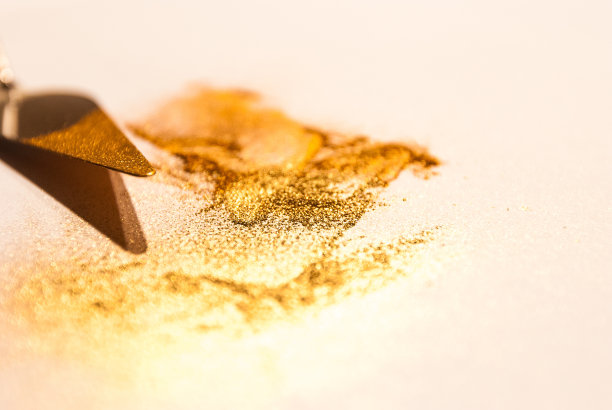 粉铲用金黄色和橙色的颜料涂在白色的纸上图片下载