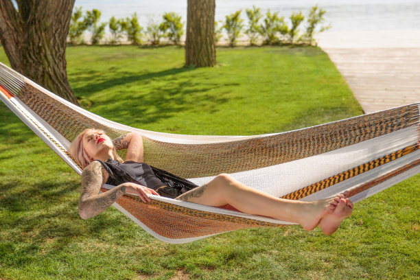 年轻的金发女子躺在吊床上图片下载