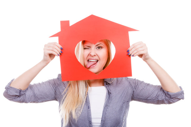 滑稽的女孩拿着红纸的心形房子图片下载