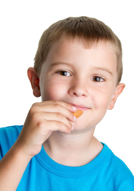 小男孩在吃杏仁。图片下载