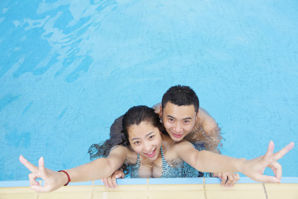 年轻的亚洲夫妇在游泳池里的照片图片下载