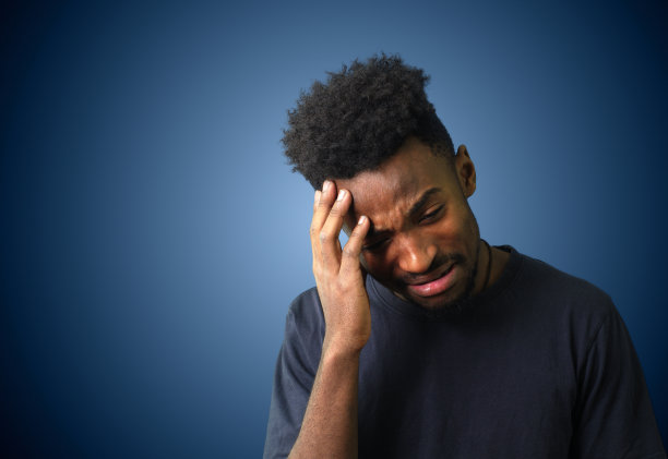 年轻人手捂着脸在摄影棚拍照素材图片