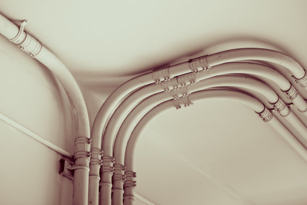 水泥墙面上的输电线管，黑白色调图片下载