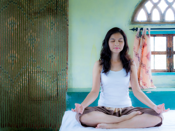 亚洲妇女训练瑜伽和冥想与阿拉伯建筑师图片下载
