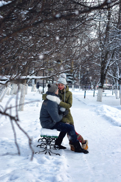 情侣们坐在冬天的长椅上图片下载