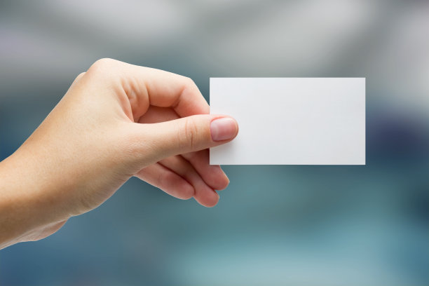 在模糊的背景上手持白色名片图片下载