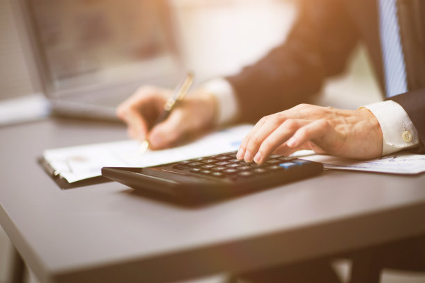 商人用计算器做他自己的会计，一份财务报告图片下载