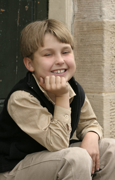 微笑的男孩坐在台阶上图片下载