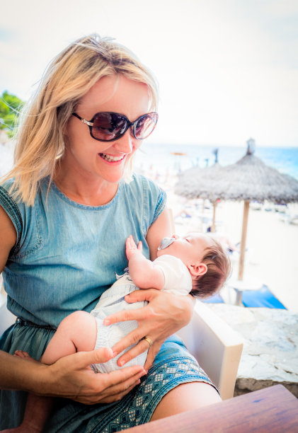 快乐的妈妈和宝宝在海滩上图片下载