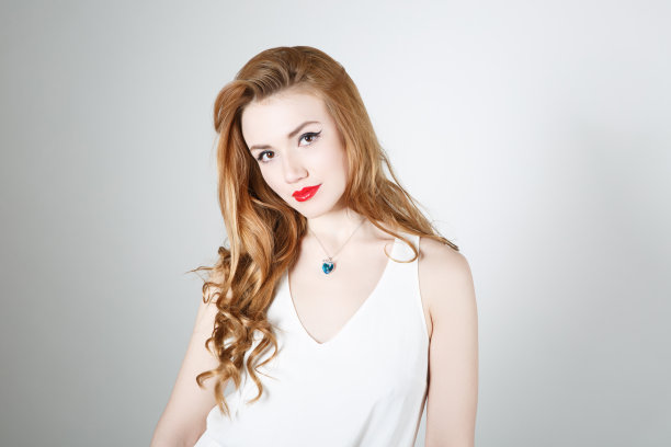 在浅色背景下，红头发的可爱女孩图片下载