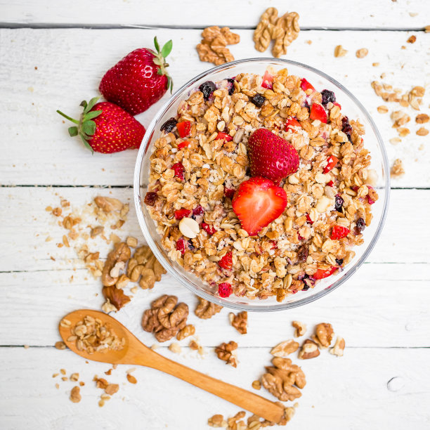 燕麦粥，蓝莓，草莓和什锦麦片在木制的背景。平的。前视图。天然美味的早餐图片下载