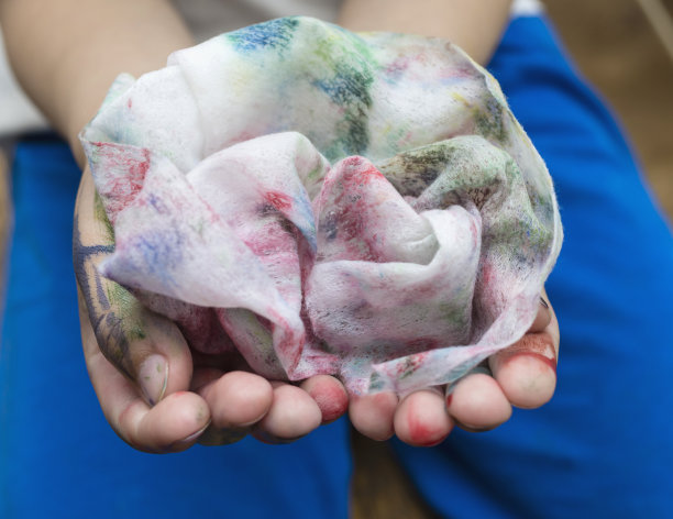 婴儿湿巾。5岁男孩擦掉手上的油漆。图片下载