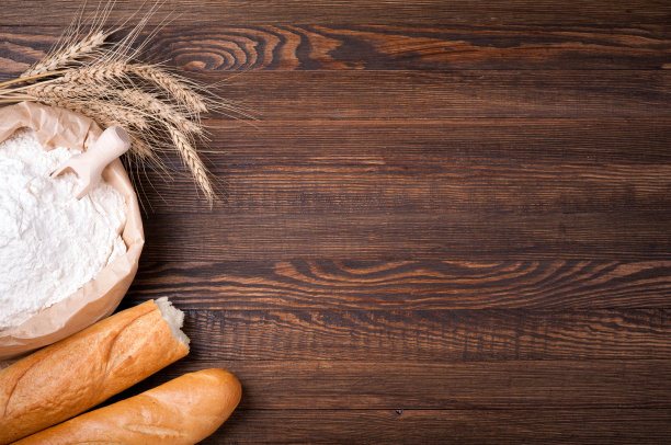 面粉纸袋，小麦和长棍面包木制背景。烘焙的背景。副本的空间。俯视图图片下载