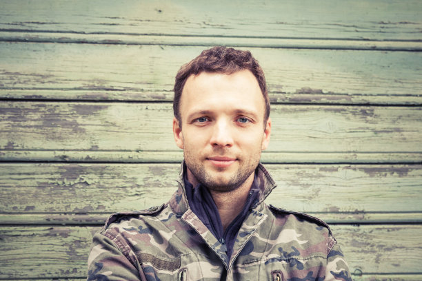 年轻的白种人穿着迷彩服。户外的肖像图片下载