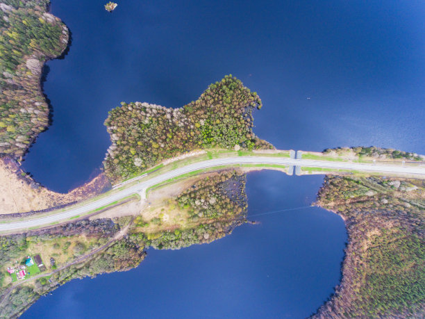 美丽的景色从一条道路穿过美丽的湖泊和森林，四周都是水，从无人机拍摄以上，空中充满活力的图片图片下载