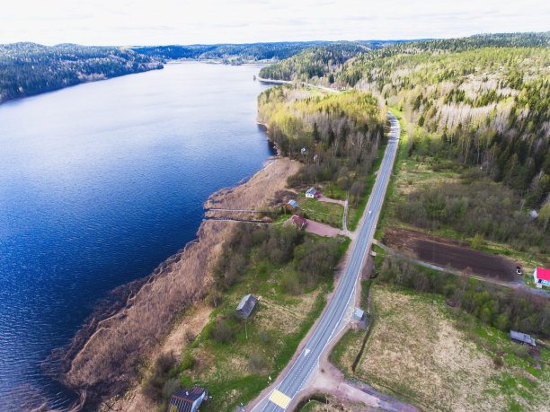 美丽的景色从一条道路穿过美丽的湖泊和森林，四周都是水，从无人机拍摄以上，空中充满活力的图片图片下载