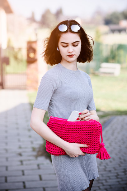 时尚女孩从手提包里拿出手机图片下载