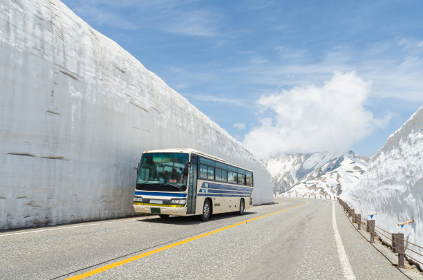 模糊的挡风玻璃和车窗巴士沿着雪墙行驶在日本阿尔卑斯山山黑袍山路上图片下载