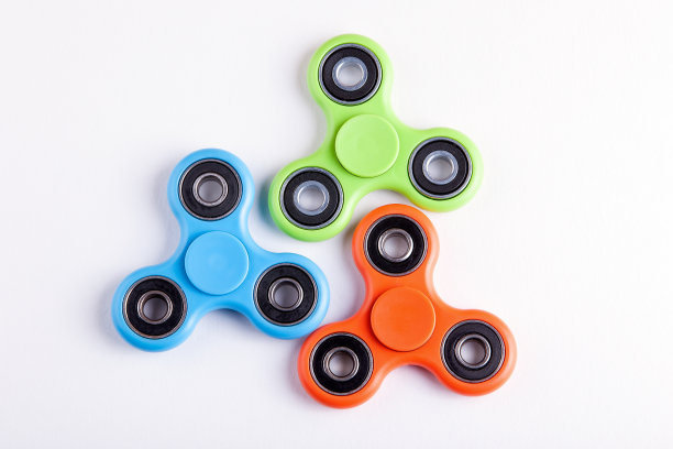 绿色，蓝色和橙色指尖陀螺应力缓解玩具在白色的背景素材图片