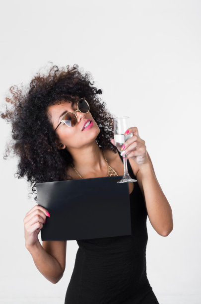 西班牙模特穿着黑色性感的衣服和太阳镜持有空白图片下载