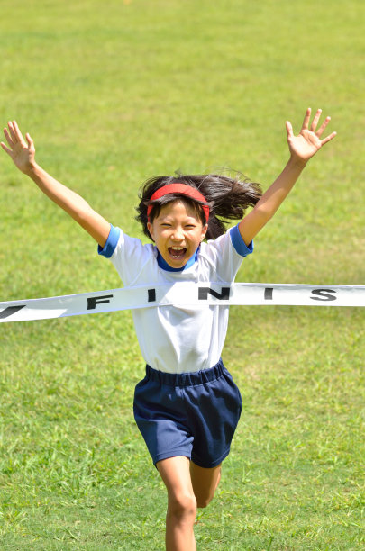 走る女の子（体操服、ゴールテープ、芝生）图片下载