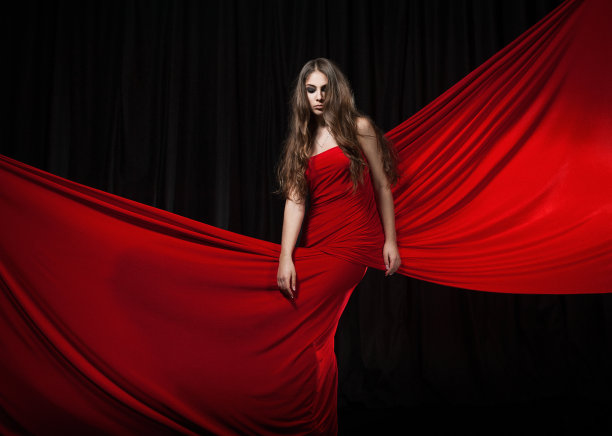 美丽的时装模特跳舞红色连衣裙，红色优雅的丝绸长袍飘扬的面料素材图片