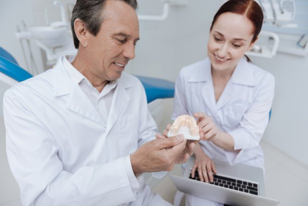 口腔医师检查下颌模型时的低角度照片图片下载