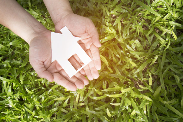 手挽着房子，背靠绿色的田野图片下载