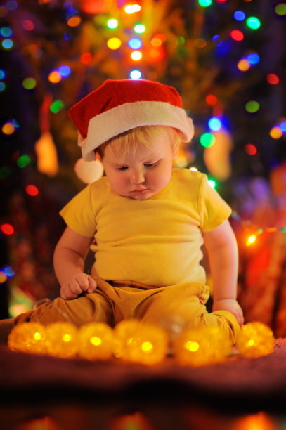 一个小男孩在圣诞树旁图片下载